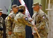 Col. Deon Maxwell, commander of U.S. Army Medical Logistics Command, passes the colors to Lt. Col. Ashley Fair during a U.S. Army Medical Materiel Center-Korea change of command ceremony July 1 at Camp Carroll, Republic of Korea. Fair assumed command of the unit from Lt. Col. Nathan Wagner.