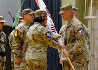 Col. Deon Maxwell, commander of U.S. Army Medical Logistics Command, passes the colors to Lt. Col. Ashley Fair during a U.S. Army Medical Materiel Center-Korea change of command ceremony July 1 at Camp Carroll, Republic of Korea. Fair assumed command of the unit from Lt. Col. Nathan Wagner.