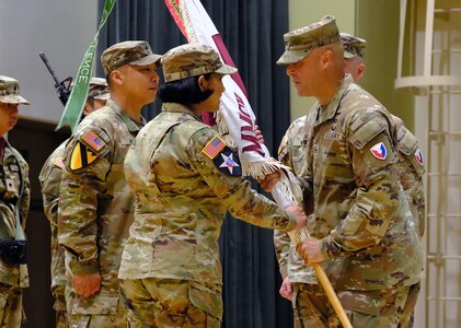 Col. Deon Maxwell, commander of U.S. Army Medical Logistics Command, passes the colors to Lt. Col. Ashley Fair during a U.S. Army Medical Materiel Center-Korea change of command ceremony July 1 at Camp Carroll, Republic of Korea. Fair assumed command of the unit from Lt. Col. Nathan Wagner.