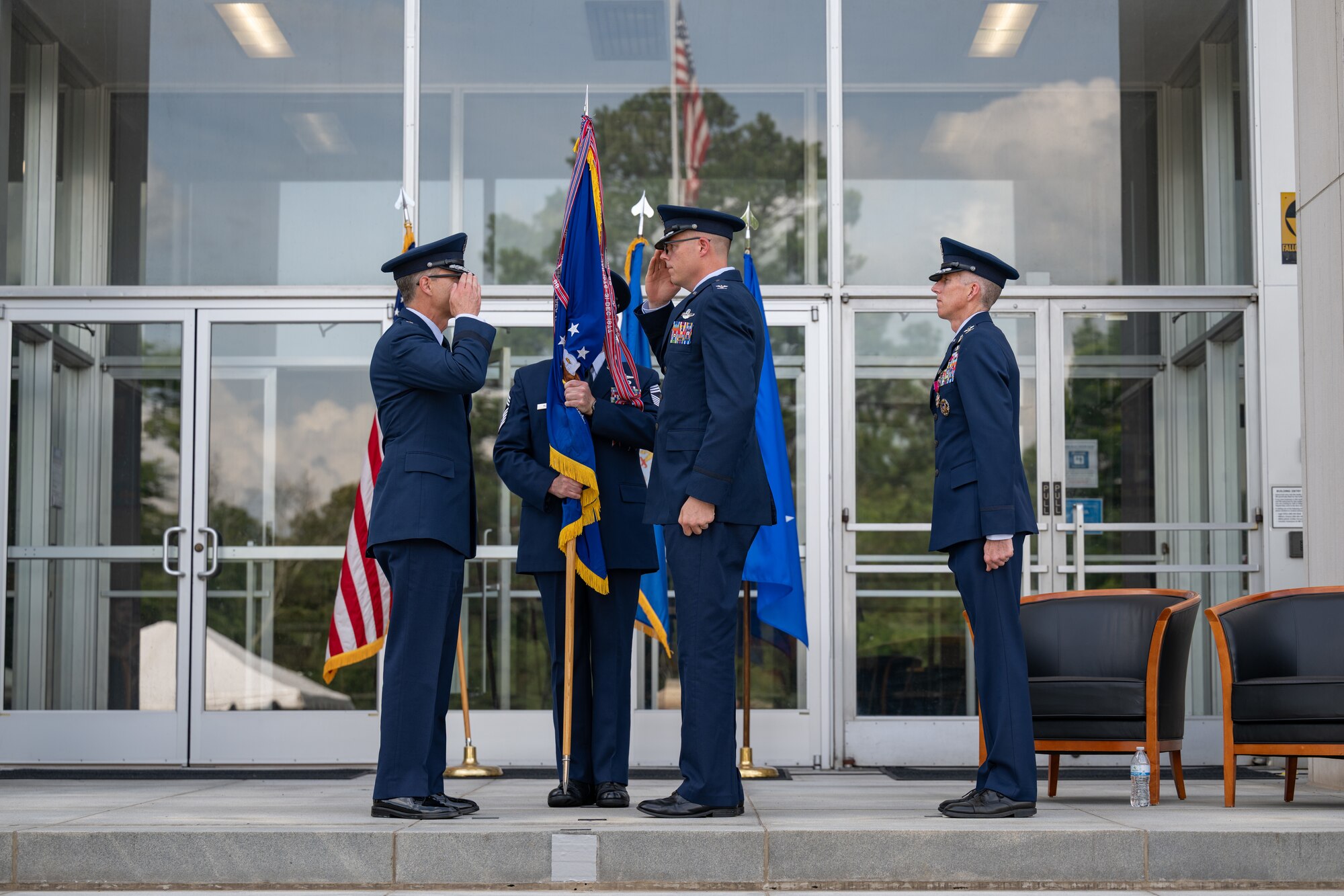 Col. Wayne Dirkes, second from right, exchanges salutes with Air Force Test Center Commander Maj. Gen. Scott Cain, left, after accepting the guidon to assume command of Arnold Engineering Development Complex during a June 27, 2026, Change of Command ceremony at Arnold Air Force Base, Tenn., headquarters of AEDC. The ceremony took place during the AEDC 75th anniversary open house celebration held on the same date at Arnold AFB. Prior to his latest assignment, Dirkes commanded the 704th Test Group, a unit of AEDC headquartered at Holloman Air Force Base, N.M. Also pictured are outgoing AEDC Commander Col. Grant Mizell, right, and AEDC Senior Enlisted Leader Chief Master Sgt. Evan McCoy. (U.S. Air Force photo by Keith Thornburgh)