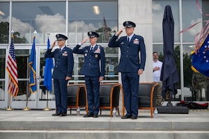 Air Force Test Center Commander Maj. Gen. Scott Cain, left, outgoing Arnold Engineering Development Complex Commander Col. Grant Mizell, center, and incoming AEDC Commander Col. Wayne Dirkes salute while the national anthem is performed prior to the AEDC Change of Command ceremony that took place June 27, 2026, as part of the AEDC 75th anniversary open house celebration at Arnold Air Force Base, Tenn., headquarters of AEDC. Outgoing AEDC Commander Col. Grant Mizell relinquished command of the Complex to incoming Commander Col. Wayne Dirkes. (U.S. Air Force photo by Keith Thornburgh)