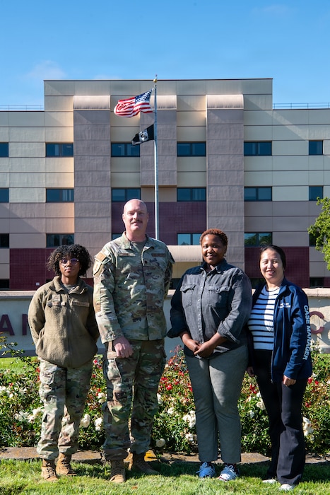 Members of the Exceptional Family Member Program staff, stand in front of the David Grant Medical Center