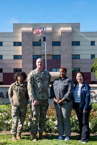 Members of the Exceptional Family Member Program staff, stand in front of the David Grant Medical Center