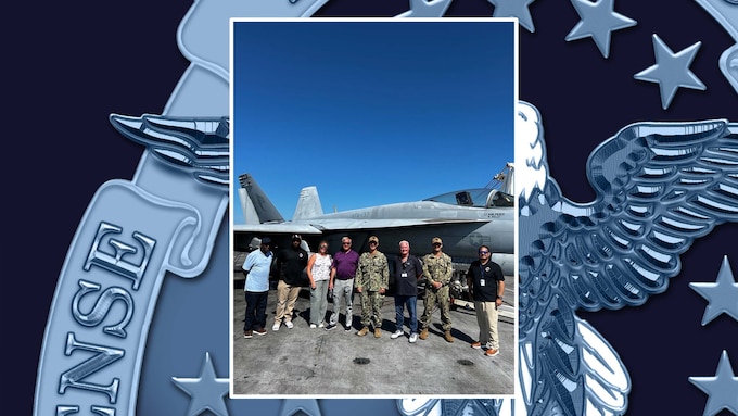 Photo of members of the Defense Logistics Agency Weapons Support at Jacksonville team standing in front of a FA/18 Super Hornet