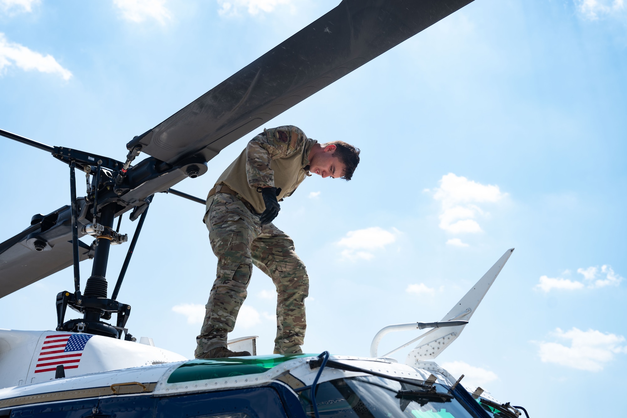 flight engineer conducts post-flight procedures on a UH-1N Huey