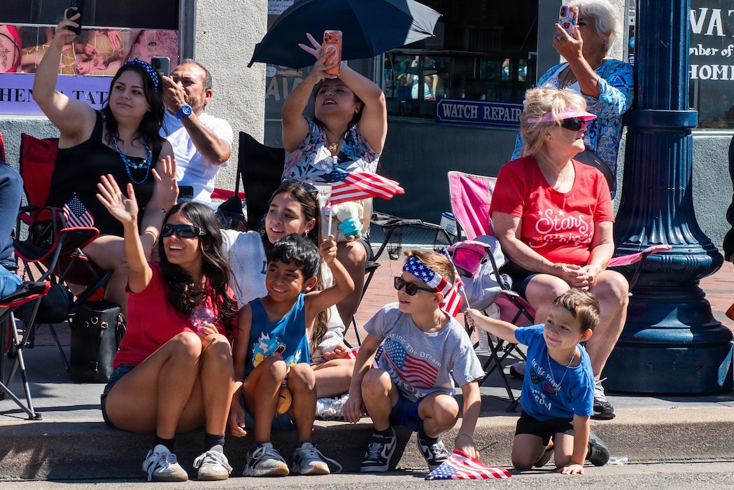 Attendees wave at performers in parade