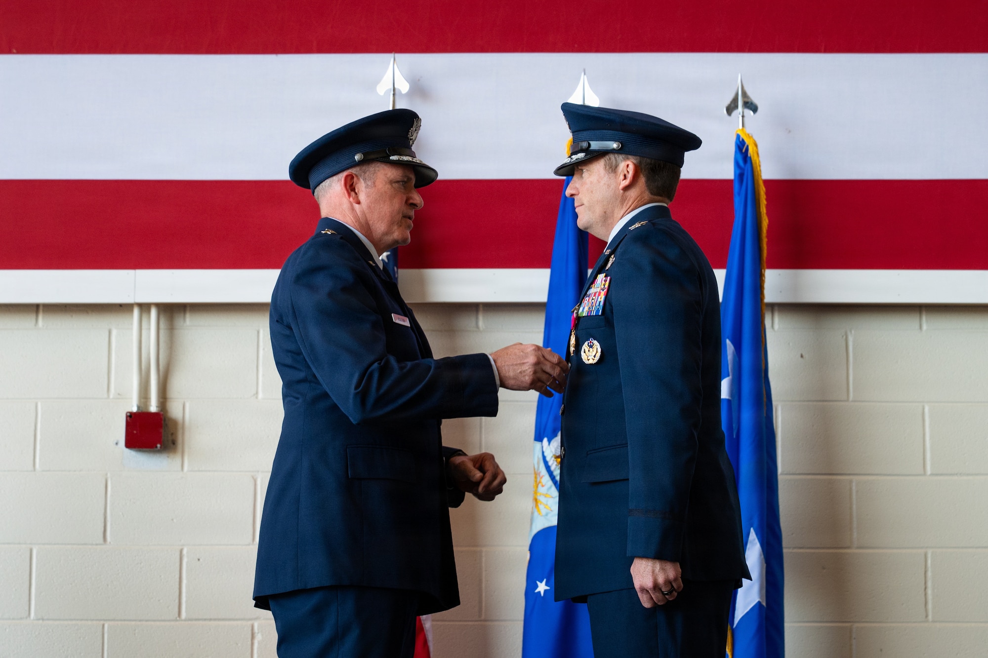 U.S. Air Force Maj. Gen. Charles Bolton, Eighteenth Air Force commander, presents the Legion of Merit to Col. Justin Diehl, outgoing 317th Airlift Wing commander, during a change of command ceremony at Dyess Air Force Base, Texas, July 8, 2026. Bolton praised the wing’s recent accomplishments under Diehl’s command, highlighting the wing’s ability to execute increasingly complex C-130J operations in both Middle East and Pacific areas-of-responsibility simultaneously. (U.S. Air Force photo by Senior Airman Jade M. Caldwell)