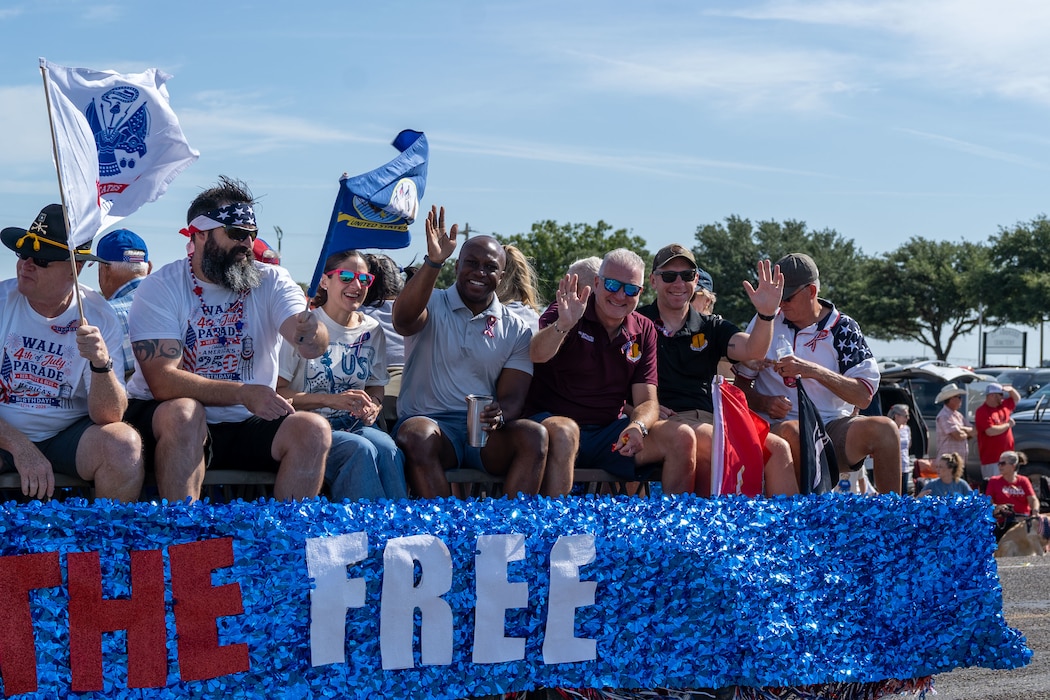 People are waving while on a parade float