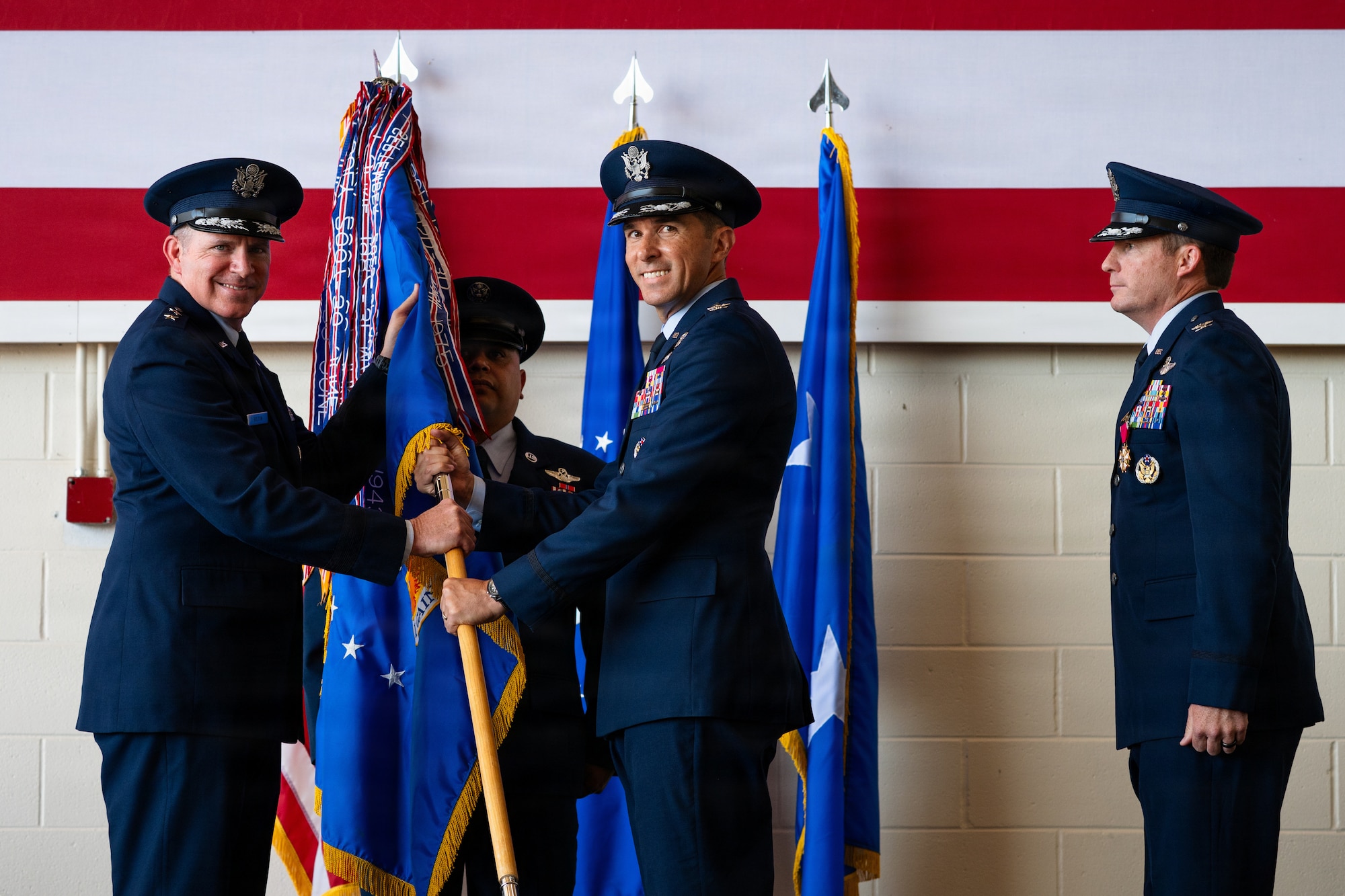 U.S. Air Force Maj. Gen. Charles Bolton, Eighteenth Air Force commander, left, passes the 317th Airlift Wing guidon to Col. Christopher Welch, incoming commander, during a change of command ceremony at Dyess Air Force Base, Texas, July 8, 2026. The passing of the guidon is a historic military tradition that symbolizes the official transfer of command, responsibility and authority from the outgoing to the incoming commander. (U.S. Air Force photo by Senior Airman Jade M. Caldwell)