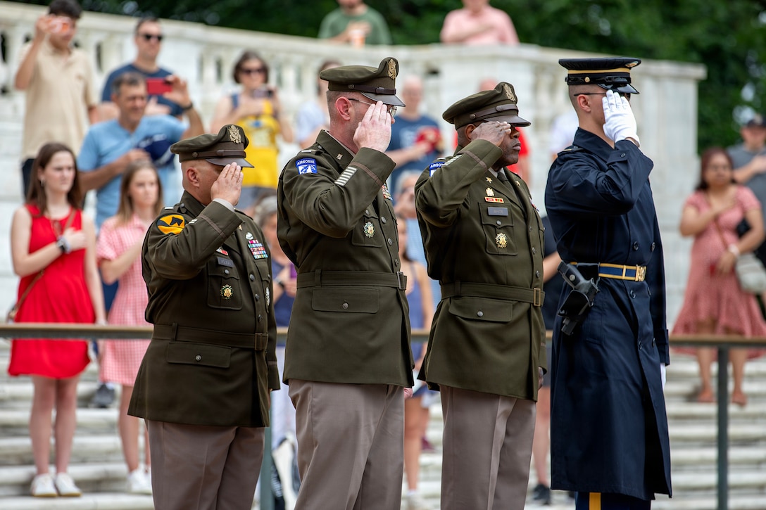 From left to right, Chief Warrant Officer 5 Bernard Aguon, Chief Warrant Officer 5 Aaron Anderson, and Chief Warrant Officer 5 LaShon White stand in dress uniform, placing a flower wreath at the Tomb of the Unknown Soldier.