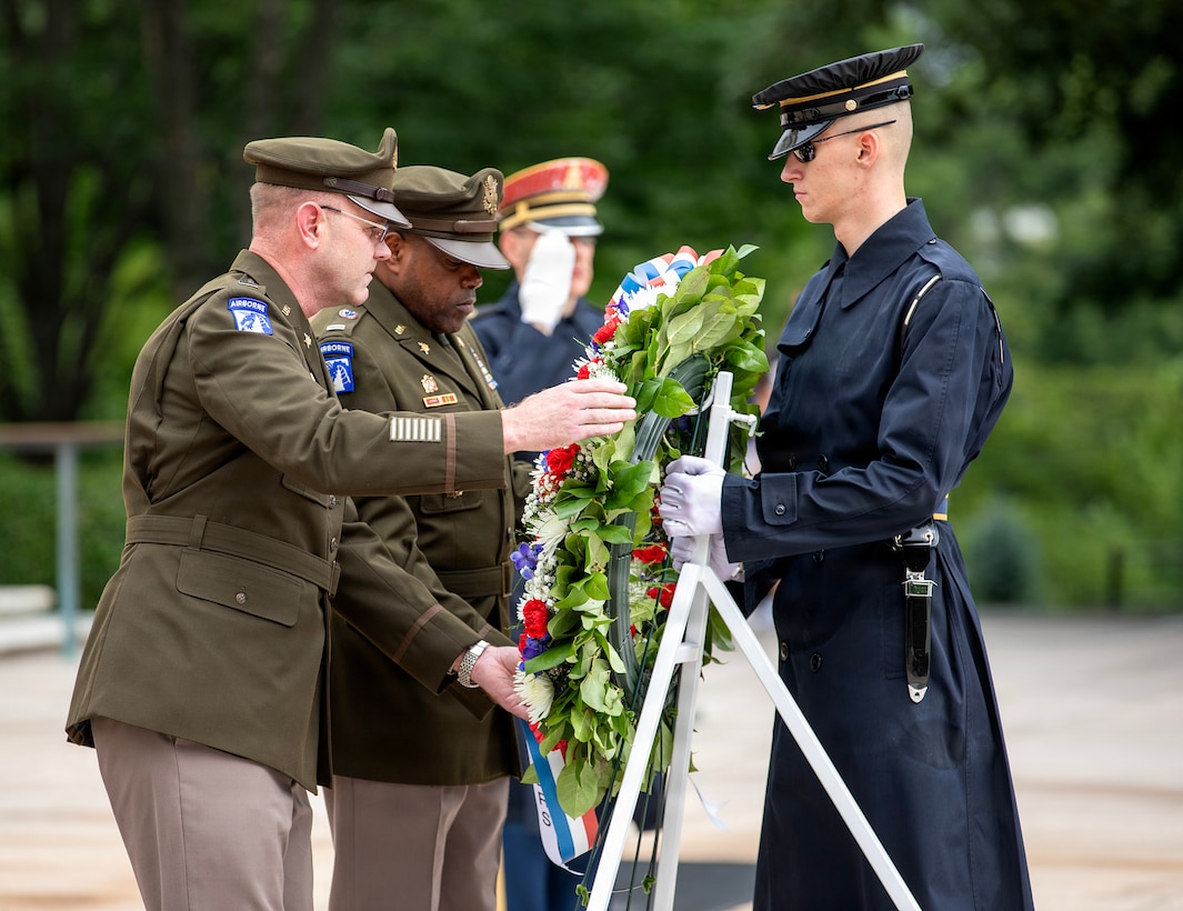 From left to right, Chief Warrant Officer 5 Aaron Anderson and Chief Warrant Officer 5 LaShon White stand in dress uniform, placing a large flower wreath at the Tomb of the Unknown Soldier.
