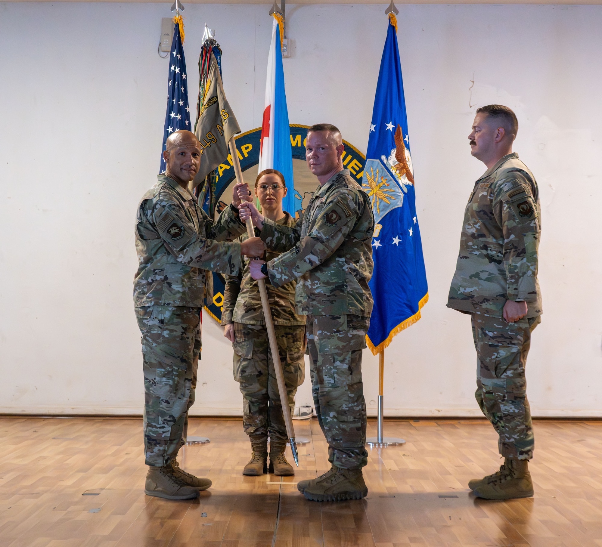 U.S. Air Force Chief Master Sgt. Nicholas Siburt, 449th Air Expeditionary Group outgoing senior enlisted leader, presents the guidon to U.S. Air Force Col. Kris Aikens, 449th AEG commander, left, during a Change of Responsibility ceremony at Camp Lemonnier, Djibouti, June 18, 2026. The Change of Responsibility Ceremony represents a formal transfer of responsibility from one senior enlisted leader to another, reinforcing their authority in the Air Force and support to the chain of command. (U.S. Air Force photo by Senior Airman Luis Gomez)