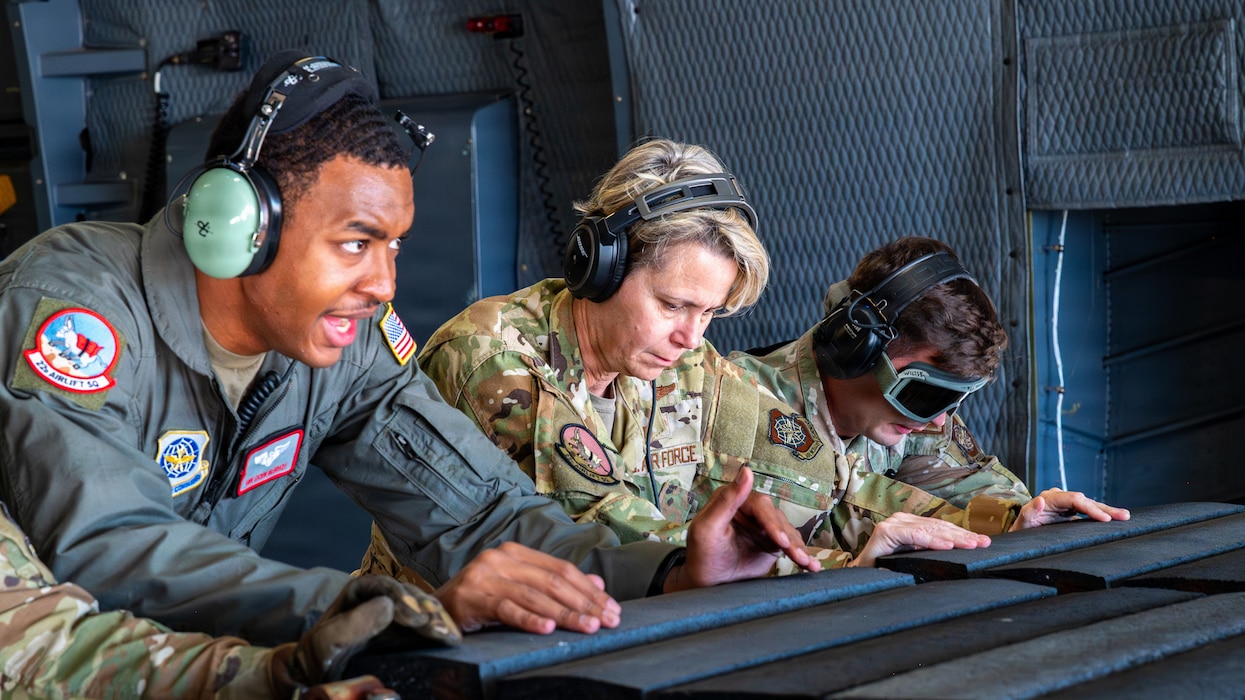 AMC interim commander pushes cargo with Airmen off aircraft.