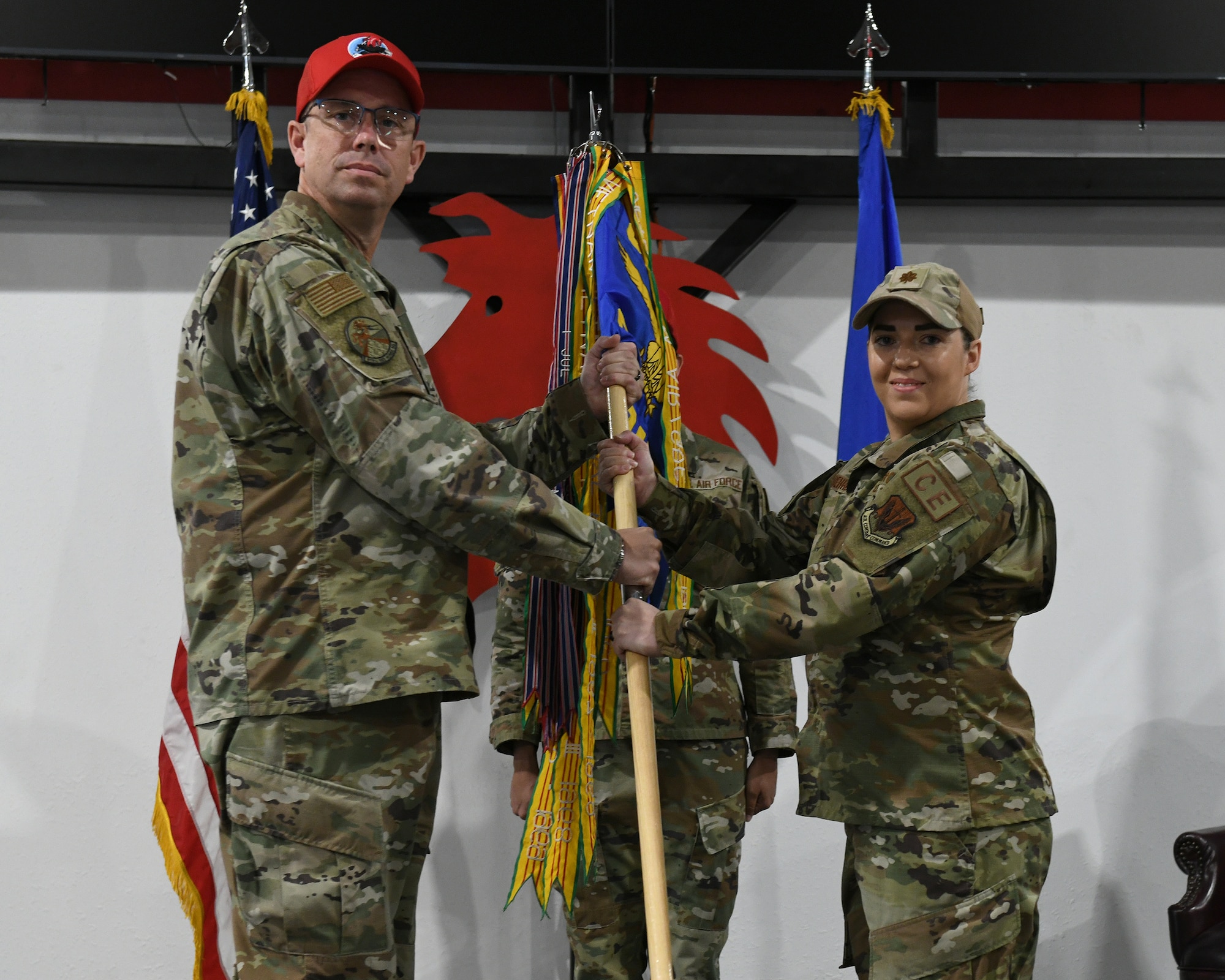 U.S. Air Force Maj. Cristina Behrens, right, accepts command of the 819th Rapid Engineer Deployable, Heavy Operation Repair Squadron, Engineer (RED HORSE) Squadron from Col. Myles Gilbert, 800th RED HORSE Group commander, during a change of command ceremony at Malmstrom Air Force Base, Montana, July 9, 2026.