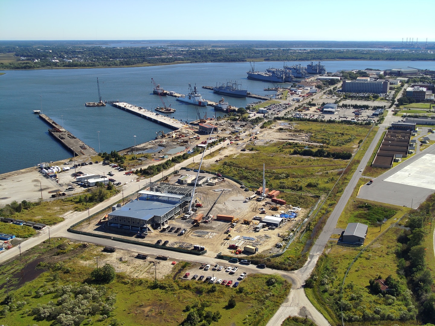 An aerial view of ongoing construction at Coast Guard Base Charleston, where the Coast Guard recently awarded a $230 million contract for new operational support facilities as part of a multi-year infrastructure expansion plan. Recent projects include construction of a 90,000-square-foot engineering complex, a 120,000-square-foot multifunctional building, a new parking structure, recapitalization of Pier Mike, and a new medical and dental facility. These efforts are part of more than $440 million in upgrades to transform Base Charleston into a premier East Coast operational base. (U.S. Coast Guard photo)