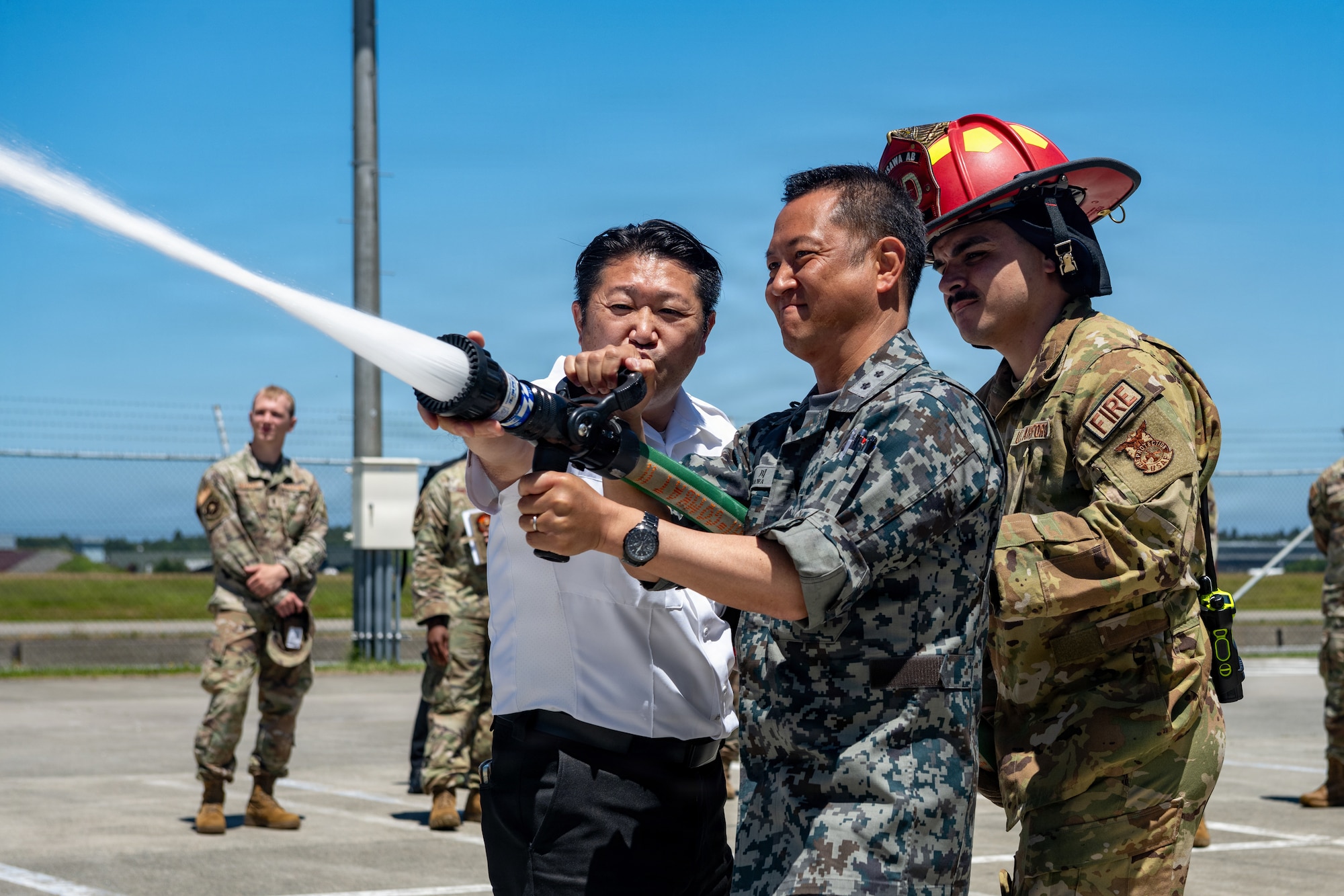 Japan Air Self-Defense Force Maj. Gen. Teru Tomikawa, 3rd Air Wing (AW) commander, operates a hose line during a 35th Fighter Wing (FW) immersion tour.