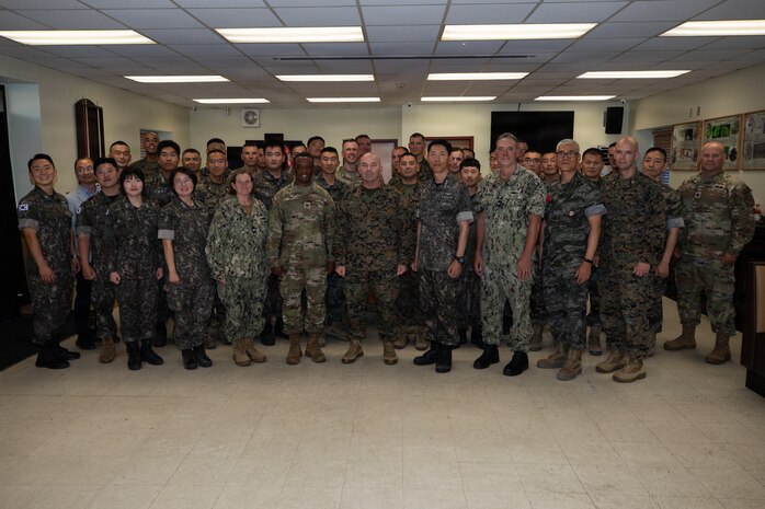 U.S. and Republic of Korea service members pose for a group photo during the opening ceremony for Combined Joint Logistics Over-the-Shore 26 at Camp Mujuk, Pohang, South Korea, July 6, 2026. CJLOTS 26 is a combined exercise designed to integrate U.S. and Republic of Korea lighterage and ship-to-shore connector capabilities, improve combined readiness, strengthen the Republic of Korea-U.S. alliance, and expand combined maritime sustainment capacity during logistics operations. (U.S. Marine Corps photo by Lance Cpl. Marcus Henson)