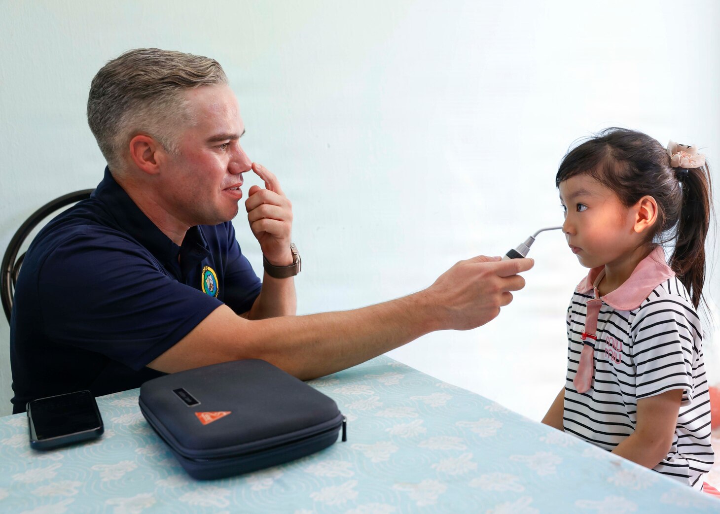 U.S. Navy Lt. Cmdr. Matthew Squires, an optometrist assigned to Pacific Partnership 2026 (PP26), performs an ocular examination for a patient during a PP26 community outreach and engagement event at the Gio Linh Center for Rehabilitation of Children with Disabilities in Quang Tri, Vietnam, June 24, 2026.