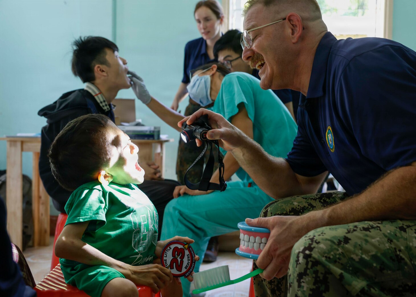 U.S. Navy Cmdr. Eric Bishoff, an oral and maxillofacial surgeon assigned to Pacific Partnership 2026 (PP26), performs a dental examination for a patient during a PP26 community outreach and engagement event at the Gio Linh Center for Rehabilitation of Children with Disabilities in Quang Tri, Vietnam, June 24, 2026.