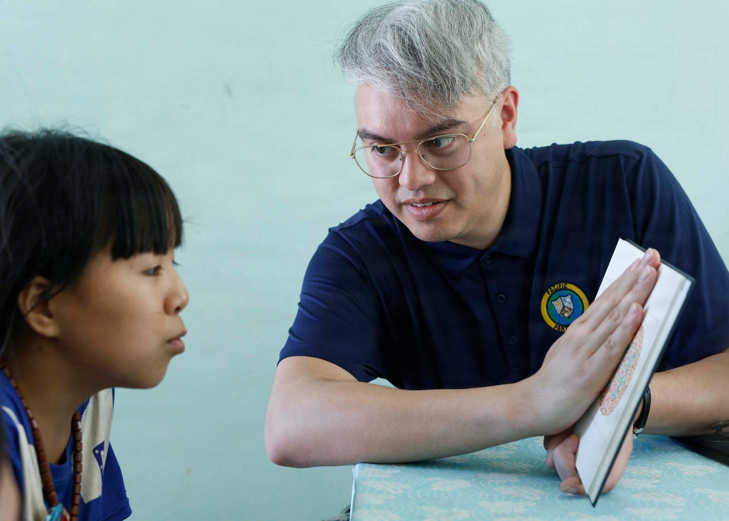 U.S. Navy Hospital Corpsman 3rd Class Vincent Stanley, an optician technician assigned to Pacific Partnership 2026 (PP26), performs a color vision and depth perception examination for a patient during a PP26 community outreach and engagement event at the Gio Linh Center for Rehabilitation of Children with Disabilities in Quang Tri, Vietnam, June 24, 2026.