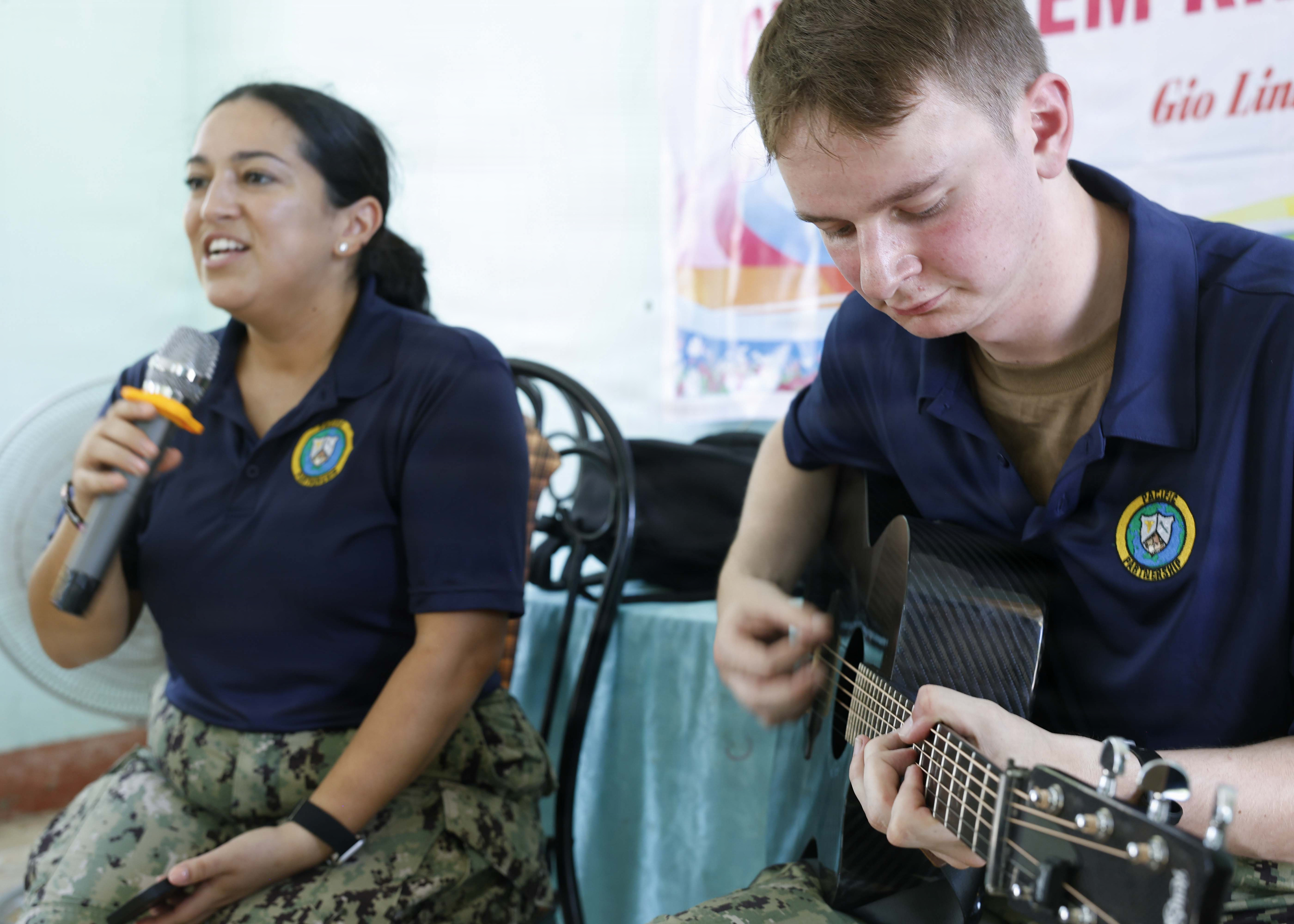 Musician 3rd Class Sean Powers, right, and Musician 3rd Class Jasmine Rodriguez, assigned to Pacific Partnership 2026 (PP26), played music for children during a PP26 community outreach and engagement event at the Gio Linh Center for Rehabilitation of Children with Disabilities in Quang Tri, Vietnam, June 24, 2026.