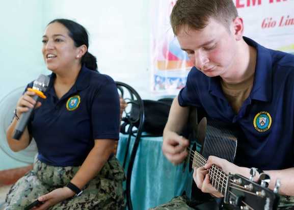 Musician 3rd Class Sean Powers, right, and Musician 3rd Class Jasmine Rodriguez, assigned to Pacific Partnership 2026 (PP26), played music for children during a PP26 community outreach and engagement event at the Gio Linh Center for Rehabilitation of Children with Disabilities in Quang Tri, Vietnam, June 24, 2026.