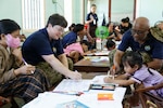 Canadian Armed Forces Cmdr. Genevieve Chatelois, left, and Canadian Armed Forces Maj. Innocent Inienwe, assigned to Pacific Partnership 2026 (PP26), draw pictures with children during a PP26 community outreach and engagement event at the Gio Linh Center for Rehabilitation of Children with Disabilities in Quang Tri, Vietnam, June 24, 2026.