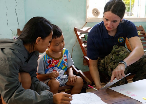 U.S. Navy Lt. Danielle Reinald, right, assigned to Pacific Partnership 2026 (PP26), draws pictures with children during a PP26 community outreach and engagement event at the Gio Linh Center for Rehabilitation of Children with Disabilities in Quang Tri, Vietnam, June 24, 2026.