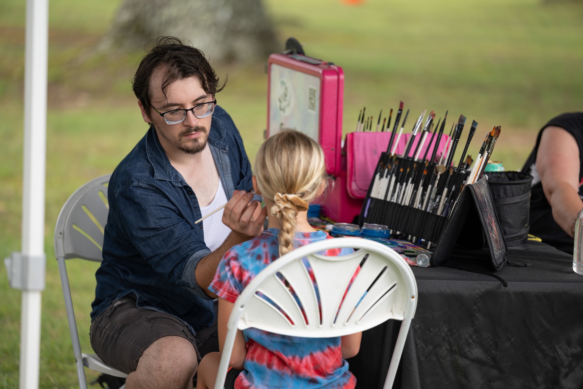 A young attendee sits down for facepainting June 27, 2026, during the Arnold Engineering Development Complex 75th anniversary open house event at Arnold Air Force Base, Tenn., headquarters of AEDC. The event included a children’s “Fun Zone” that, along with facepainting, featured inflatables, trampolines and a petting zoo. (U.S. Air Force photo by Keith Thornburgh)