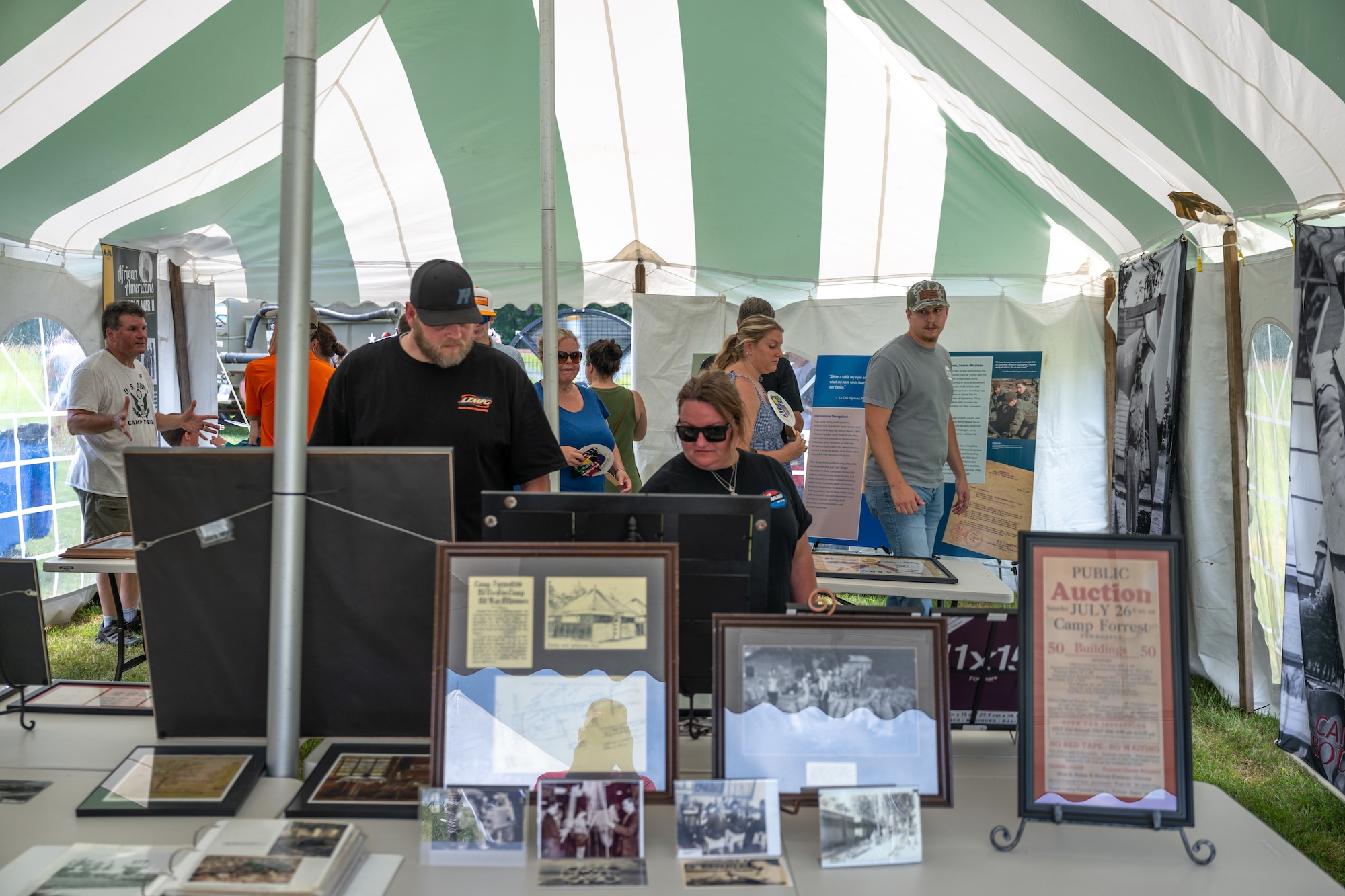 Attendees gets look over some of the items on display in one of the Arnold Engineering Development Complex history tents set up during the AEDC 75th anniversary open house celebration June 27, 2026, at Arnold Air Force Base, Tenn., headquarters of AEDC. The public open house was held to coincide with the original June 25, 1951, dedication of AEDC. (U.S. Air Force photo by Keith Thornburgh)