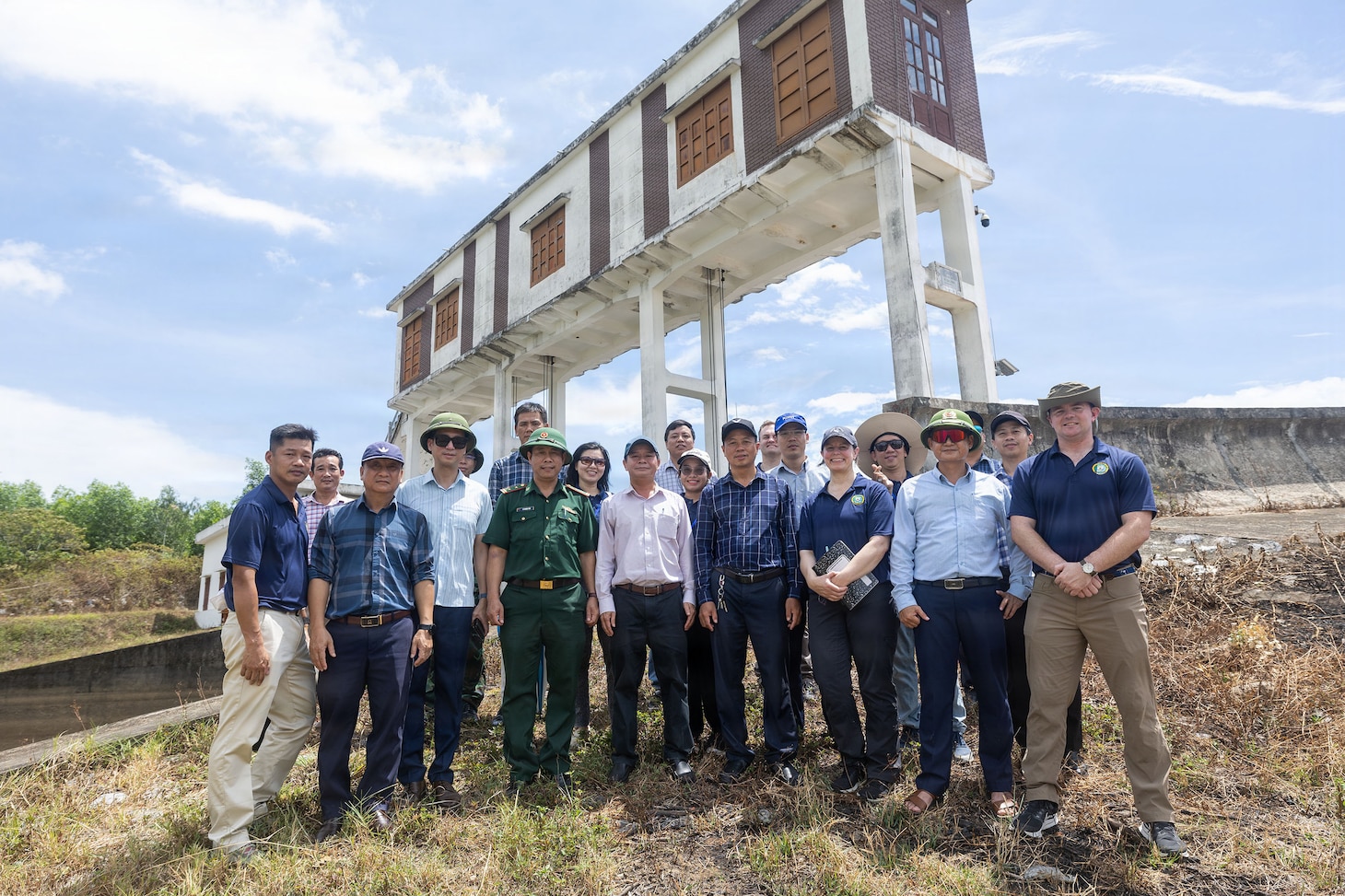 Servicemembers assigned to Pacific Partnership 2026 (PP26) and Quang Tri Sub-department of Irrigation and Disaster Prevention members pose for a photo at Phu Vinh reservoir during a PP26 disaster management field training exercise in Quang Tri, Vietnam, July 2, 2026.