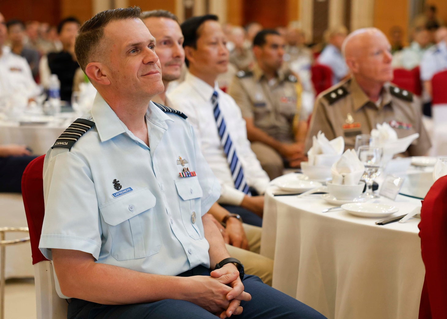 Canadian Armed Forces Col. Alain Lafrenière, left, deputy mission commander of Pacific Partnership 2026 (PP26), watches a video commemorating the PP26 and Pacific Friendship 2026 (PF26) mission in Vietnam, during the PP26 and PF26 joint closing ceremony in Quang Tri, Vietnam, July 3, 2026.
