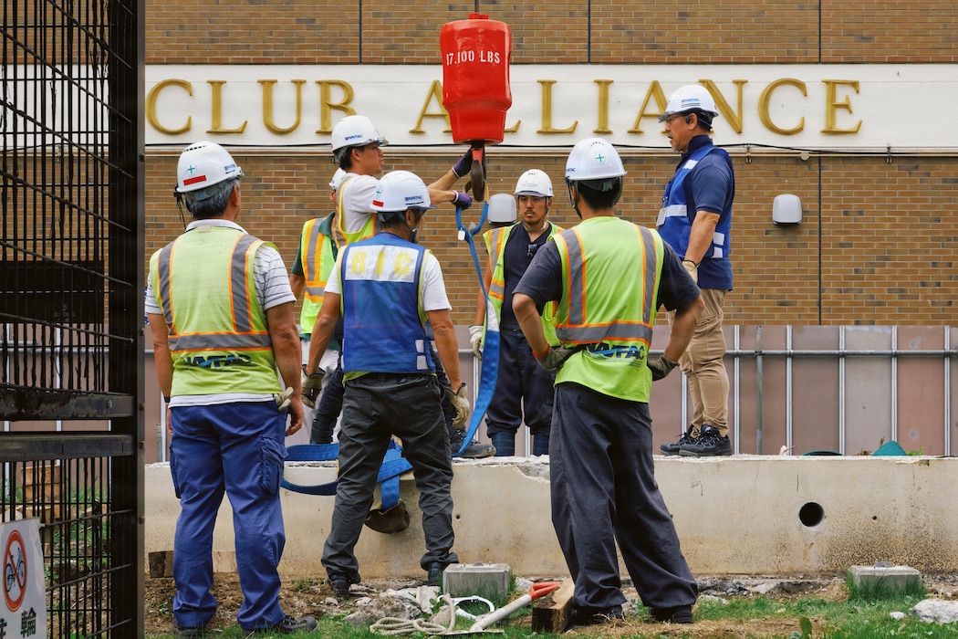 Commander, Fleet Activities Yokosuka Public Works Department (CFAY PWD) and Naval Facilities (NAVFAC) Far East personnel remove the decorative sign in front of Club Alliance June 14, 2026 to make way for the installation's Water Line Repair scheduled later in the week.