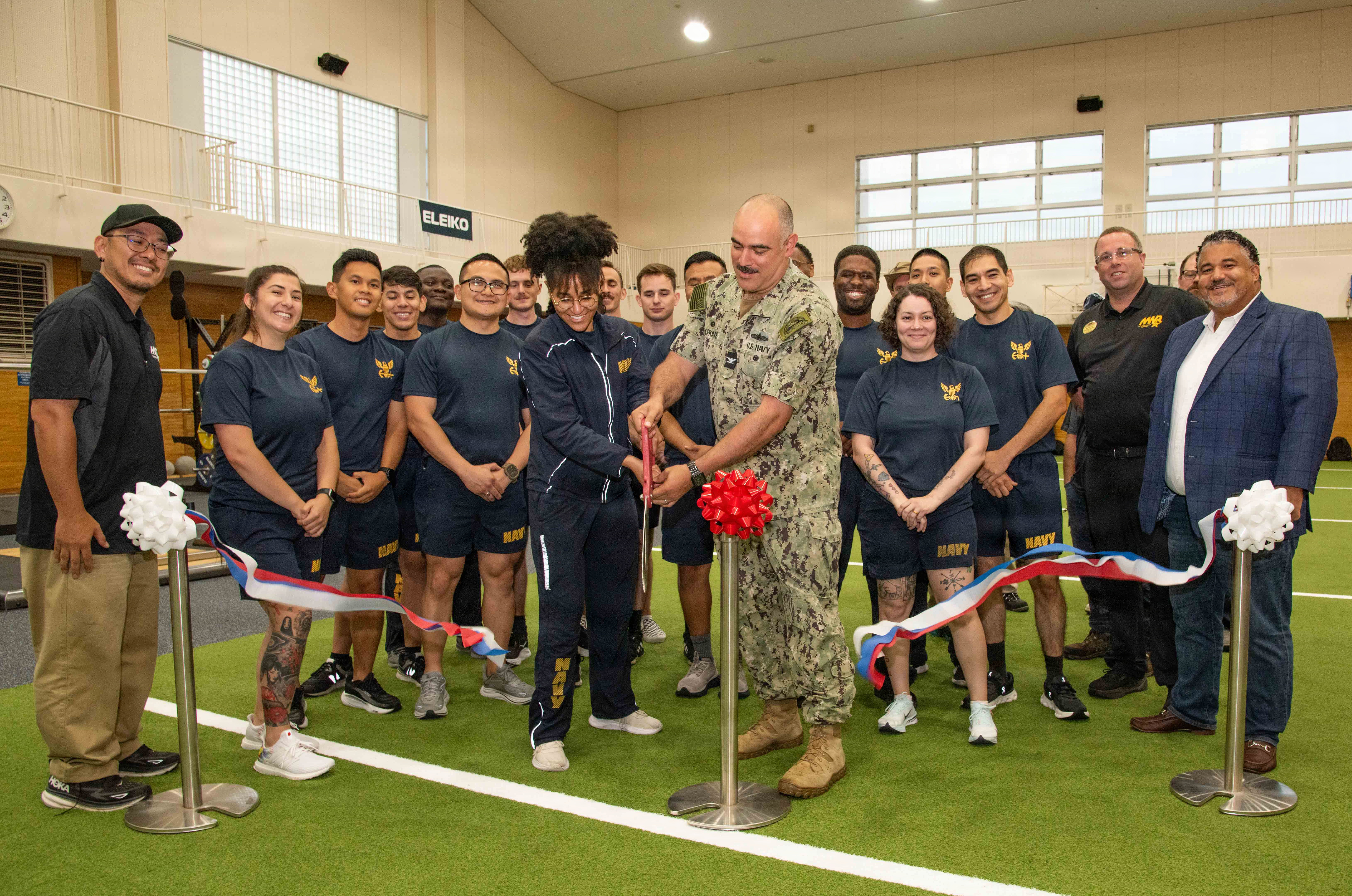 Capt. Jon Hopkins, Commander, Fleet Activities Yokosuka (CFAY) and Mass Communication Specialist 2nd Class Victoria Armstrong, with Fleet Public Affairs Center Yokosuka, joined by other command fitness leaders from local area commands, cut the ribbon during a grand opening ceremony for the Navy Operational Fitness and Fueling System (NOFFS) zone in Purdy Gym.