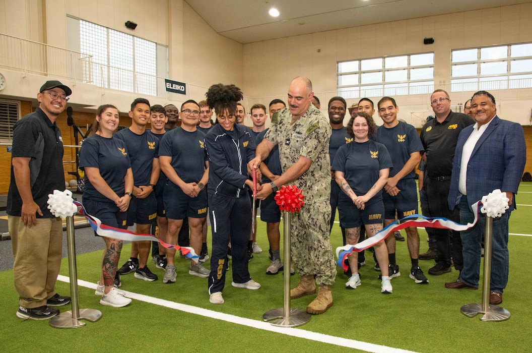 Capt. Jon Hopkins, Commander, Fleet Activities Yokosuka (CFAY) and Mass Communication Specialist 2nd Class Victoria Armstrong, with Fleet Public Affairs Center Yokosuka, joined by other command fitness leaders from local area commands, cut the ribbon during a grand opening ceremony for the Navy Operational Fitness and Fueling System (NOFFS) zone in Purdy Gym.