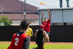 A participant jumps in the air to catch a frisbee.