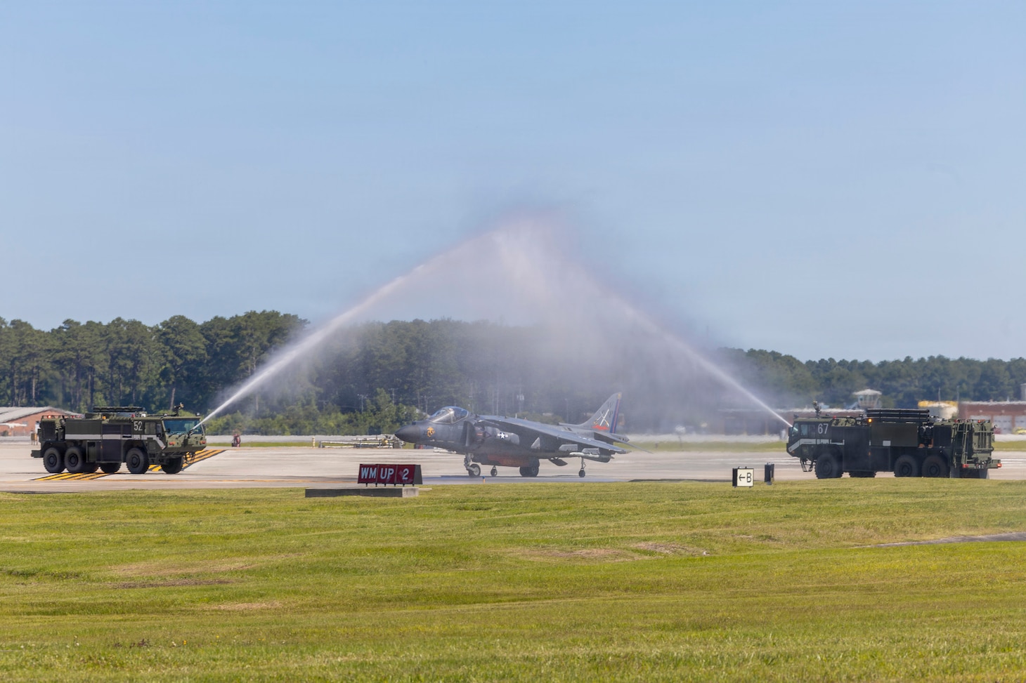 A U.S. Marine Corps AV-8B Harrier II with Marine Attack Squadron (VMA) 223, Marine Aircraft Group 14, 2nd Marine Aircraft Wing, passes under a water salute at Marine Corps Air Station Cherry Point, June 3, 2026. The “sundown” of the AV-8B Harrier II, an iconic aircraft that has supported joint and Marine Corps operations for over 40 years, also represents the dawn of a new era; it paves the way for 2nd MAW’s full transition to the F-35B and C Lightning II. VMA-223 is the U.S. Marine Corps' last operational Harrier squadron.