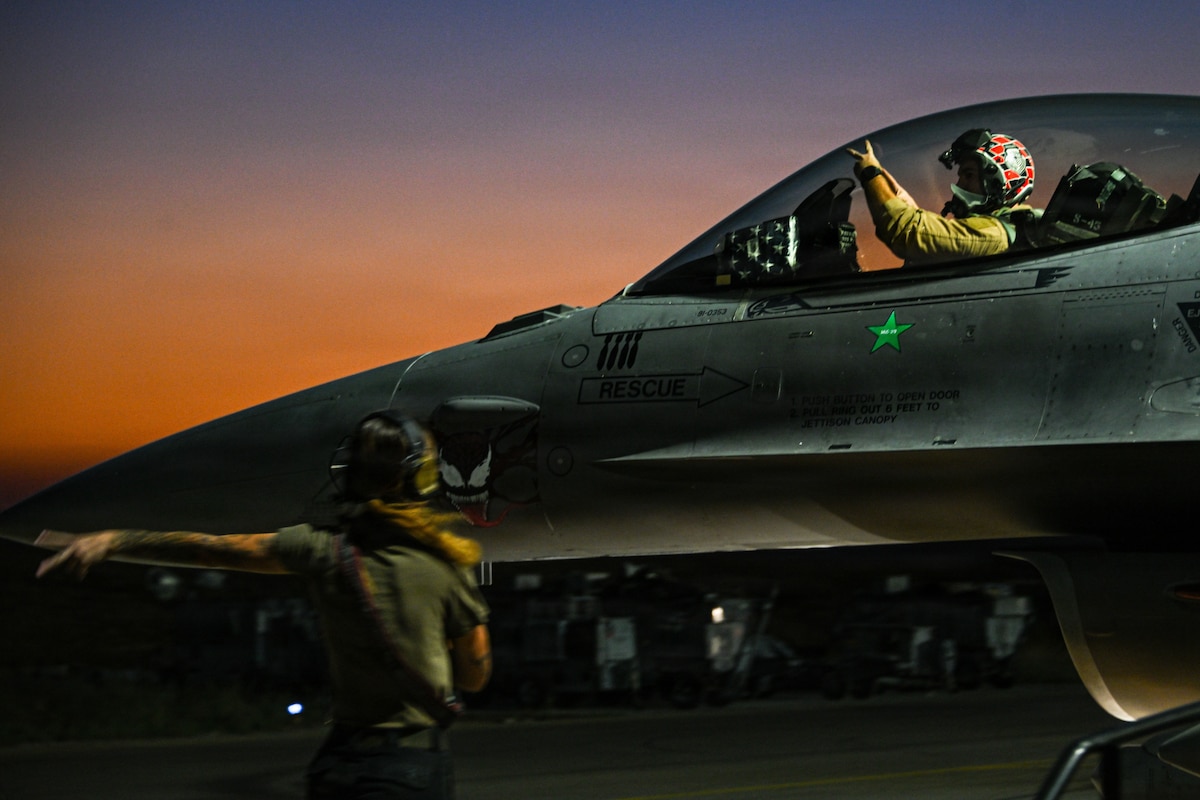 A crew chief marshals a U.S. Air Force F-16 Fighting Falcon before taxiing at an undisclosed location within the U.S. Central Command area of responsibility, June 16, 2026. The sortie supported ongoing regional operations and maintained the aircraft’s readiness to provide airpower across the theater. (U.S. Air Force photo by Staff Sgt. Justin W. Moore)