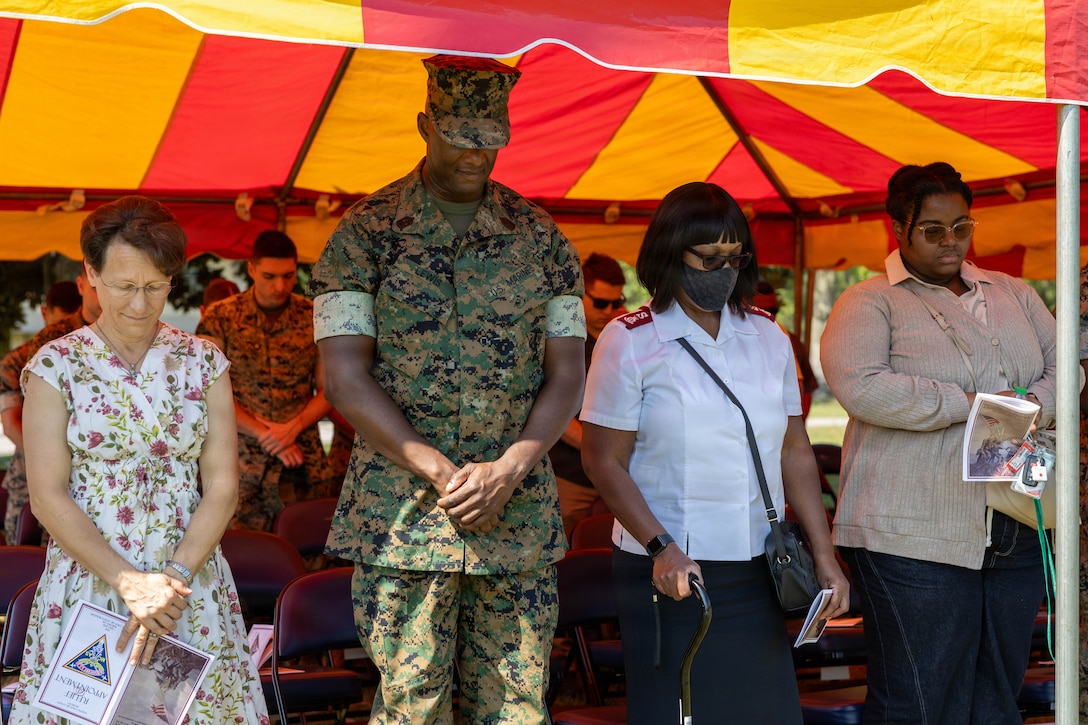 The wife of U.S. Marine Corps Col. Trevor J. Felter, commanding officer, Marine Corps Air Station Beaufort, left, Sgt Maj. Lacey J. Lewis, in-coming sergeant major, MCAS Beaufort, center, families, and friends pray during a Relief and Appointment Ceremony at MCAS Beaufort, South Carolina, July 1, 2026. The ceremony recognized Sgt. Maj. Bryan M. Alfaro, out-going sergeant major, MCAS Beaufort, for his service, leadership and dedication to the unit while welcoming Lewis. (U.S. Marine Corps photo by Cpl. Isabella Renaud)