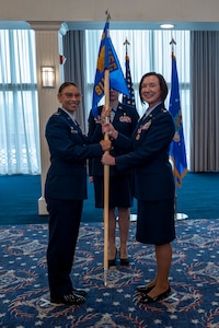 A photo of Air Force Col. and lt. Col. holding a guidon facing the camera.