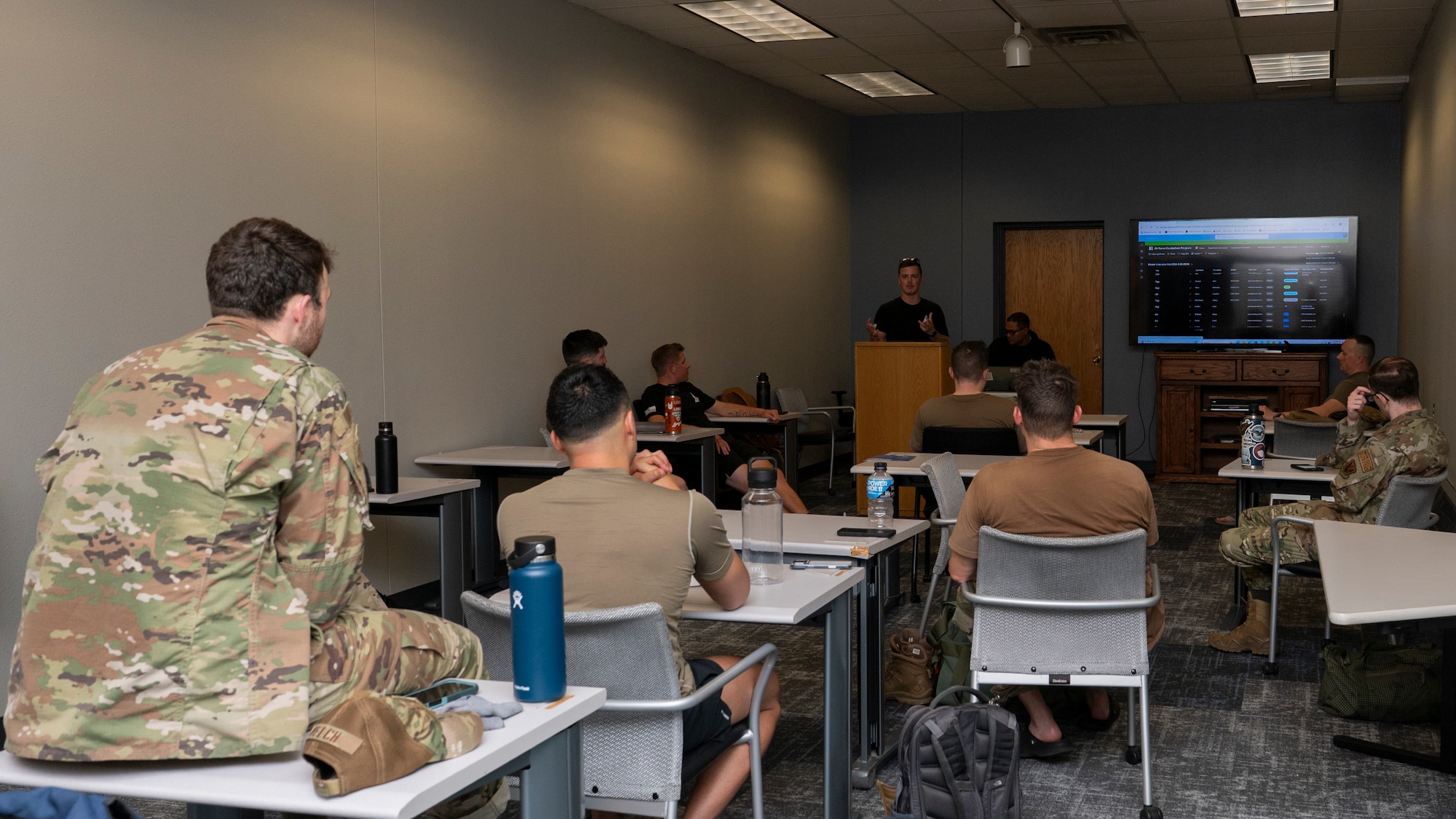 Airmen are in a classroom learning about combatives.