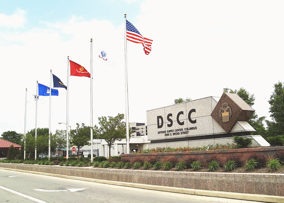 A sign that reads DSCC with flags from 2004.