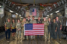 U.S. Airmen posing together for a photo on a C-17 Globemaster III cargo plane.