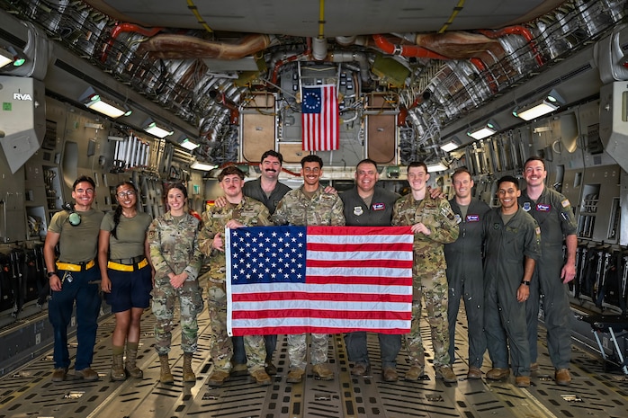 U.S. Airmen posing together for a photo on a C-17 Globemaster III cargo plane.