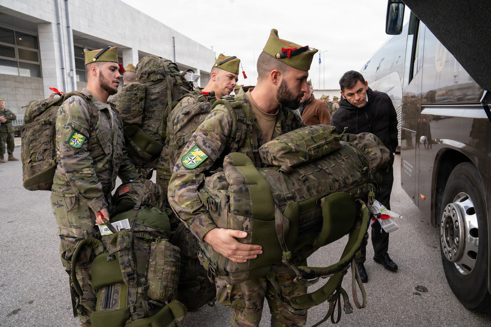 Spanish service members with the Spanish Legion and operating under the NATO Allied Reaction Force (ARF) load their luggage into buses after arriving at Alexandroupolis Airport, Greece, during the Strategic Deployment portion of NATO Exercise Steadfast Dart 2025.