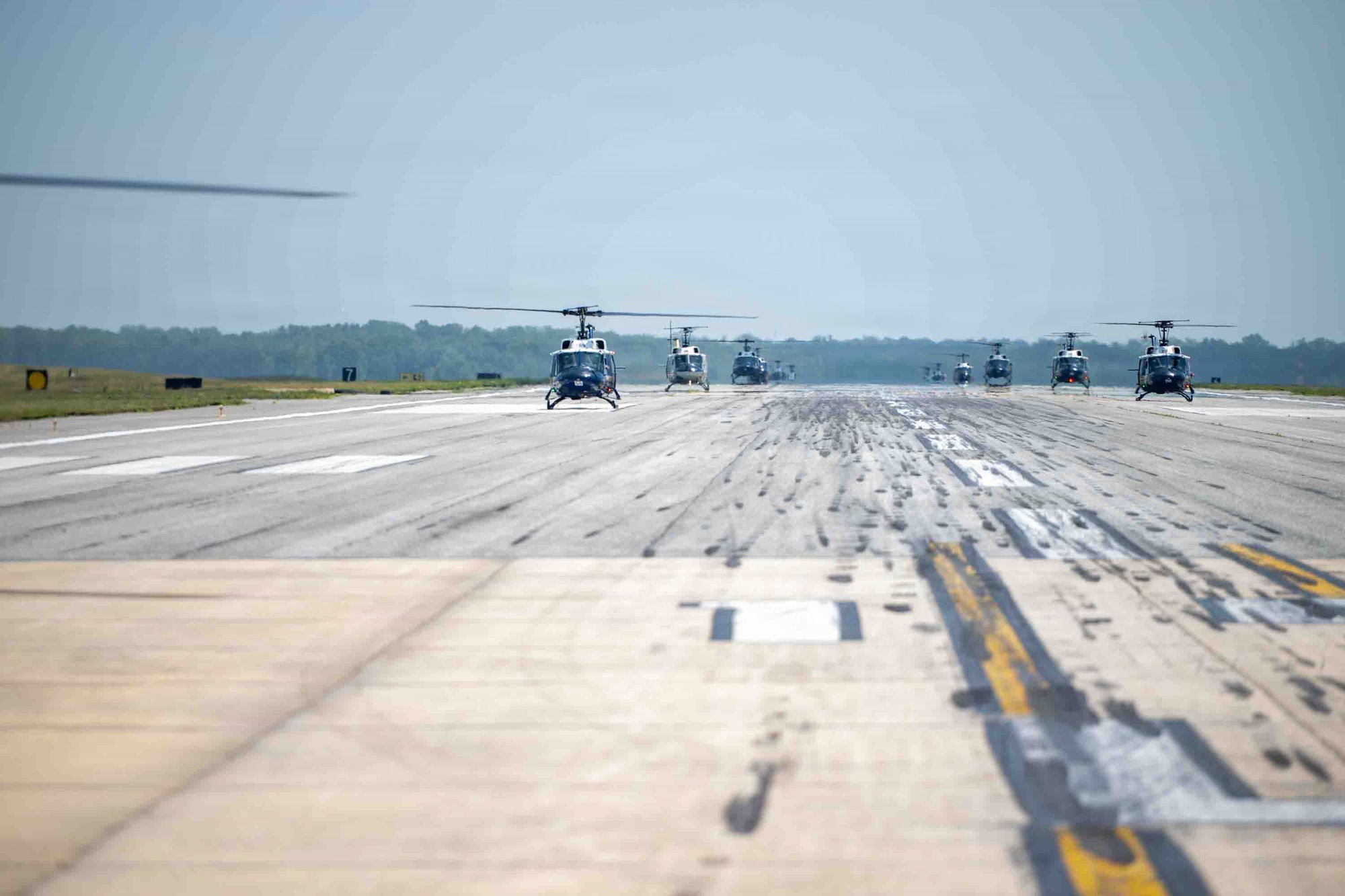 A formation of 15 UH-1N Hueys assigned to the 1st Helicopter Squadron taxi into position for an Elephant Walk.