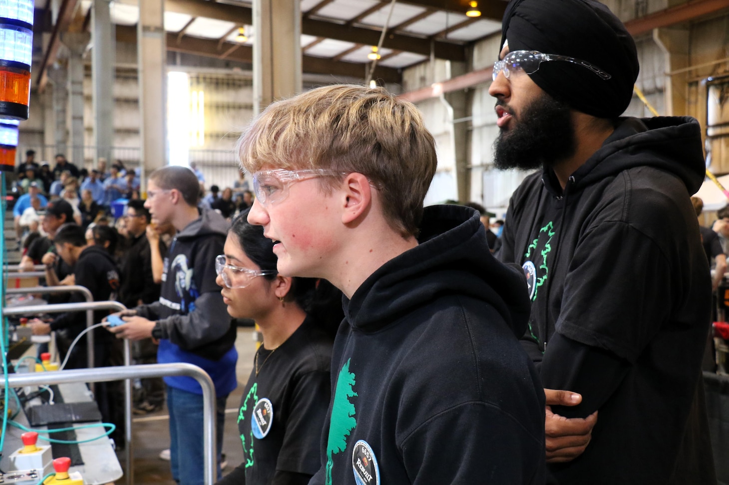 The drive team for Team 6657, the Arborbotics, operate their robot from the alliance station during a qualification match at the California District Hueneme Port Event at FATHOMWERX in Port Hueneme, Calif., March 8.