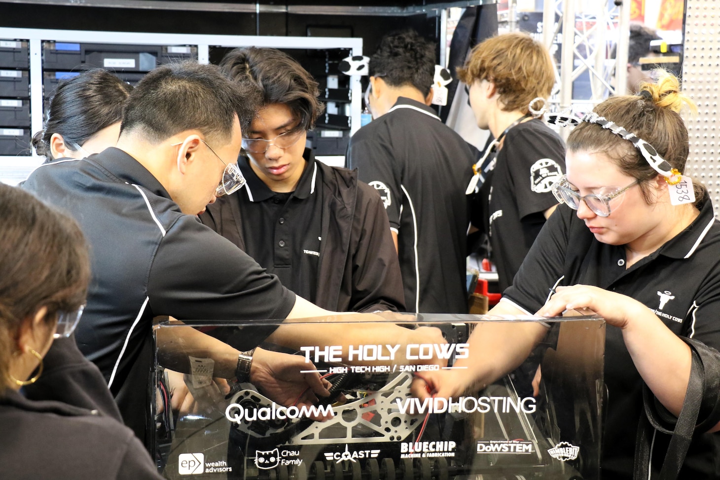 Members of The Holy Cows, a FIRST Robotics Competition team from High Tech High in San Diego, work on their robot in the pit area during the California District Hueneme Port Event at the Port of Hueneme, Calif., March 8.