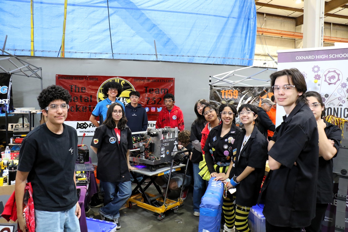 Patrick Schuett, director of Air Wing Integration and Interoperability/Electronic Warfare Effects at Naval Air Warfare Center Weapons Division, visits the pit area of NAWCWD-sponsored Team 4711, the Flying Aces, from ACE Charter High School in Camarillo, during the California District Hueneme Port Event at FATHOMWERX in Port Hueneme, Calif., March 8.