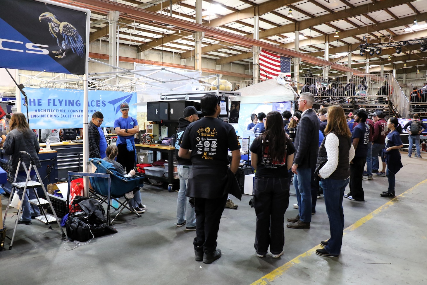Patrick Schuett, director of Air Wing Integration and Interoperability/Electronic Warfare Effects at Naval Air Warfare Center Weapons Division, visits the pit area of NAWCWD-sponsored Team 4711, the Flying Aces, from ACE Charter High School in Camarillo, during the California District Hueneme Port Event at FATHOMWERX in Port Hueneme, Calif., March 8.